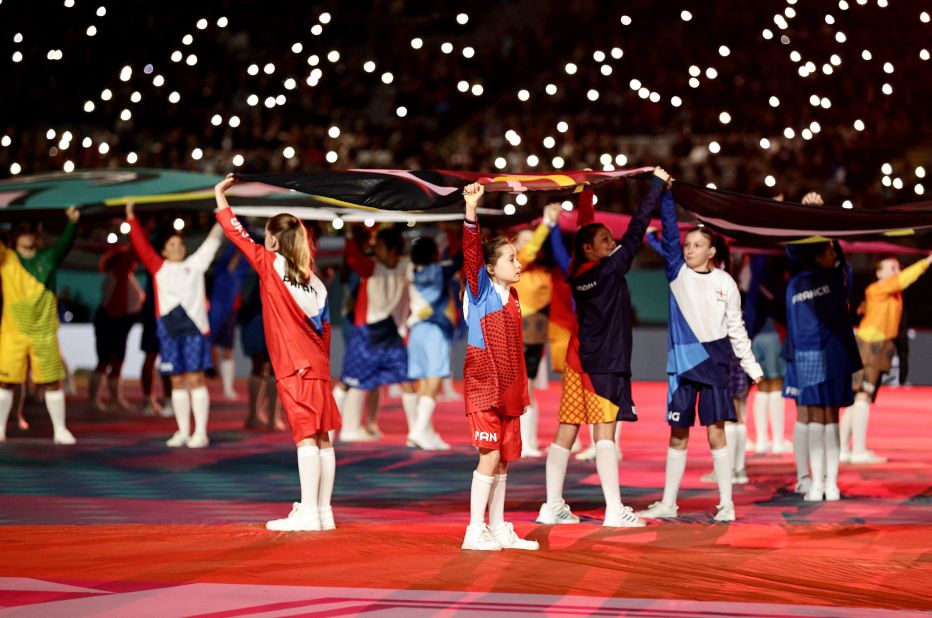 Children hold flags during the opening ceremony.