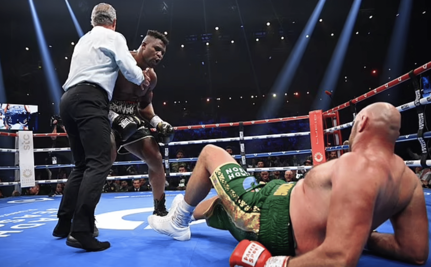 Fury ngã xuống sàn sau cú đấm mạnh của Ngannou. Ảnh: AFP