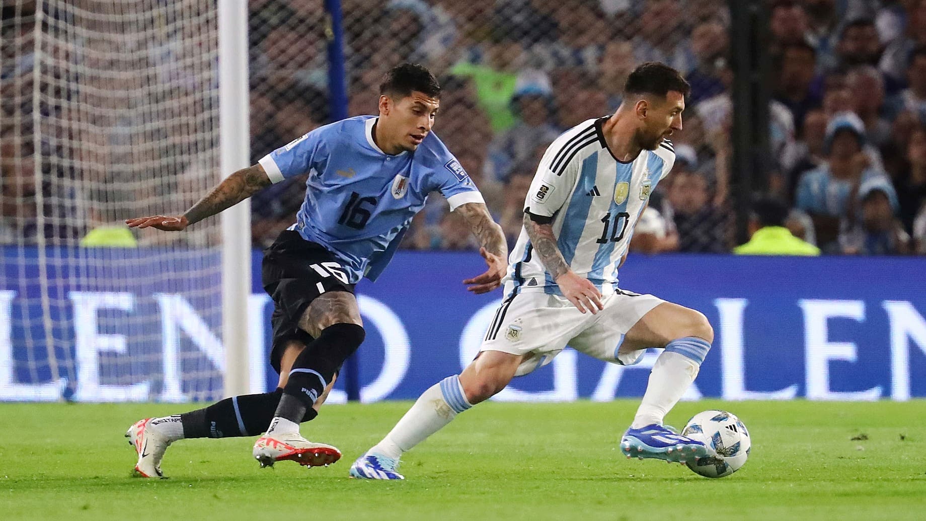 Messi (phải) đi bóng trong sự theo kèm của trung vệ Olivera bên phía Uruguay hôm 16/11. Ảnh: AP